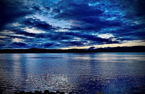 Photo of stormy blue horizons over lake