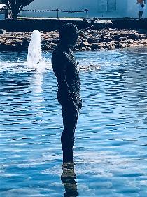 Male statue in the marina at high tide 